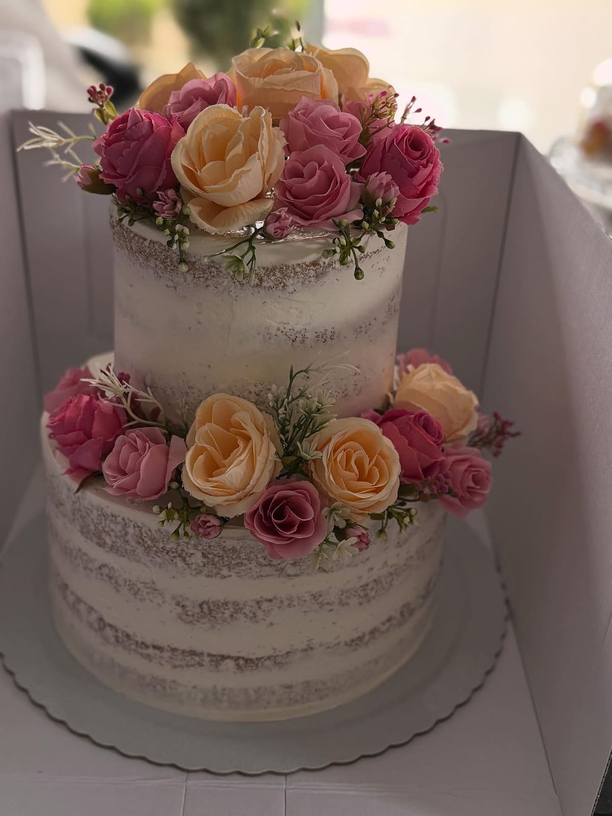 Naked cake de dois andares decorado com rosas em tons de rosa e pêssego